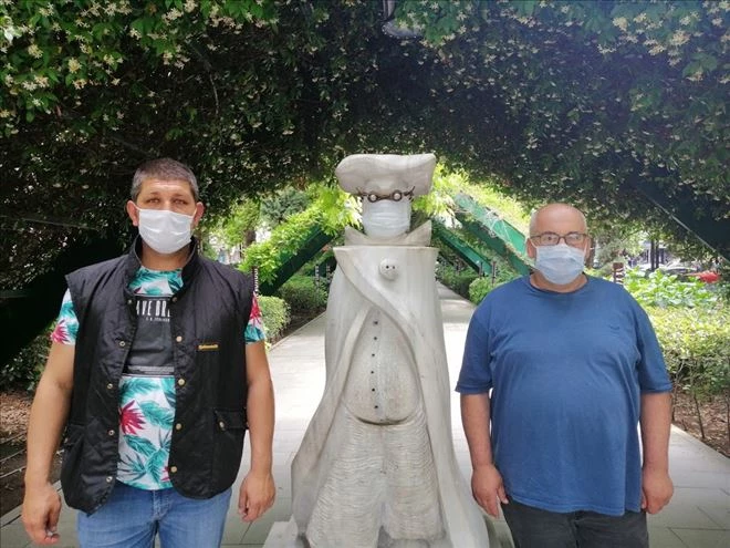 Taksiciler farkındalık için heykele maska taktı